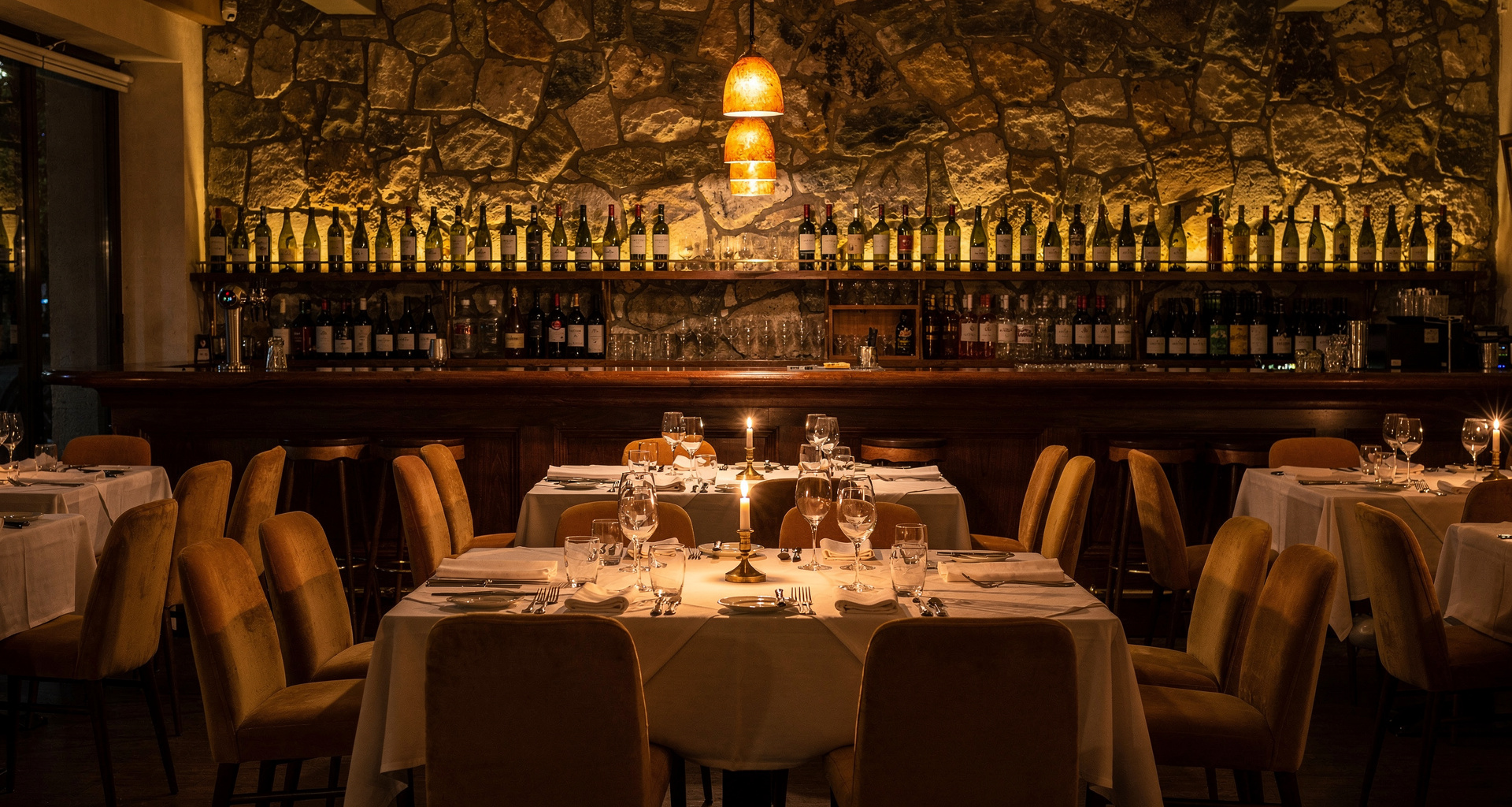 Warm candlelit modern Italian dining room at MISTO with timber tables and soft ambient lighting